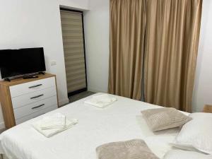 een slaapkamer met een bed en een televisie op een dressoir bij Daniel Apartment in Năvodari