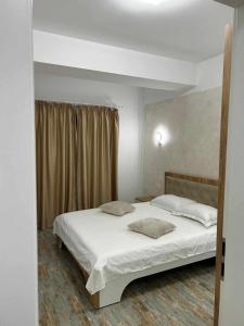 - une chambre avec un lit et 2 oreillers dans l'établissement Daniel Apartment, à Năvodari