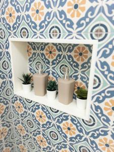 a bathroom with a shelf with plants and tiles at Apartamentos Pepita in San Sebastián de la Gomera