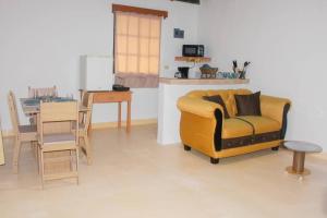 a living room with a yellow chair and a table at Confortable y céntrico in Comayagua