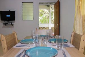une table avec des assiettes et des verres bleus dans l'établissement Confortable y céntrico, à Comayagua