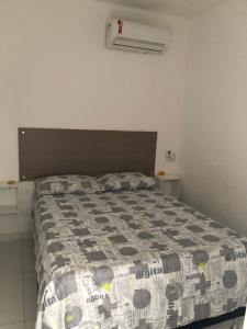 a bedroom with a bed with a comforter on it at Village Mamelucos frente para Praia do Flamengo in Salvador +16 photos