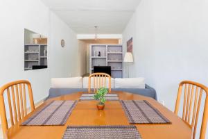 uma sala de jantar com uma mesa e um sofá azul em Seaside escape apartment em Palaiá Fókaia