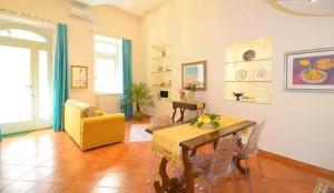 a living room with a table and a yellow chair at Luxury Apartment Federica N 1 Centro Storico di Taormina in Taormina