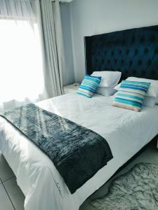 1 cama con cabecero negro y 2 almohadas en Kyalami Boulevard Estate, Kyalami Hills ext 10 Robin Road Midrand en Midrand