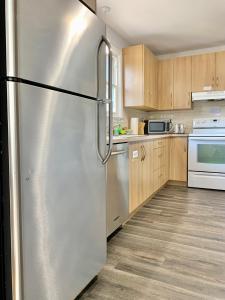 a stainless steel refrigerator in a kitchen with wooden cabinets at Simply Stays in Ottawa