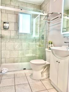 La salle de bains blanche est pourvue de toilettes et d'un lavabo. dans l'établissement Simply Stays, à Ottawa