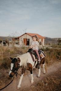a little girl riding on top of a horse at Paradise Ranch Chapada dos Veadeiros in Alto Paraíso de Goiás
