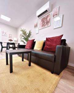 a living room with a black couch and a table at Apartamentos Pepita in San Sebastián de la Gomera