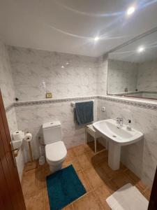 ein Badezimmer mit einem weißen WC und einem Waschbecken in der Unterkunft Can Andre in Sant Jordi