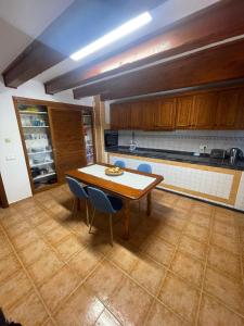 a kitchen with a wooden table and blue chairs at Can Andre in Sant Jordi