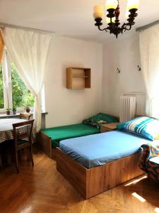 sypialnia z 2 łóżkami, stołem i oknem w obiekcie Rooms by Kino Femina w Warszawie