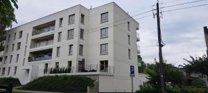 un edificio blanco con balcones en un lateral en Apartament "Słoneczny" Kraszewskiego en Węgorzewo