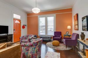 a living room with two chairs and a tv at NEW! Orange Street Downtown Cottage in Hot Springs