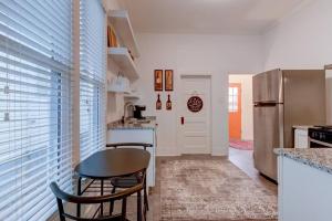 a kitchen with a table and a refrigerator at NEW! Orange Street Downtown Cottage in Hot Springs