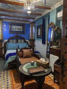een blauwe slaapkamer met een bed en een tafel bij Riad Azurite in Chefchaouene