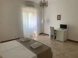 a bedroom with a bed and a desk with a computer at Porta Napoli Rooms in Lecce