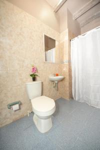 y baño con aseo blanco y lavamanos. en Casa Hotel Terraza del Cabrero, en Cartagena de Indias