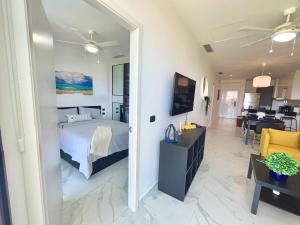 a bedroom with a bed and a living room at Cana Rock Star, Apartamento Lujo Vista Golf Infinity Pool A-410 in Punta Cana