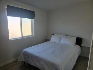 a bedroom with a bed with white sheets and a window at Starlite View in Valle