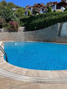 a large blue swimming pool next to a brick wall at Turkish riviera sea view detached villa in Gazipasa