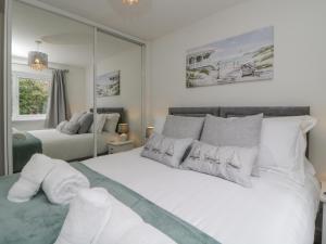 a bedroom with a large white bed and a mirror at Ocean Retreat in Paignton