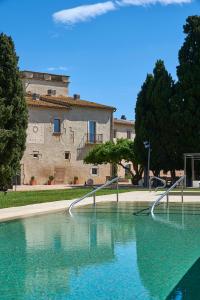 una grande piscina d'acqua di fronte a un edificio di URH - Hotel Molí del Mig a Torroella de Montgrí