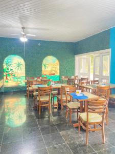 une salle à manger avec des tables et des chaises en bois dans l'établissement Pousada Hotel Canto dos Mares, à Guarujá