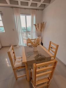 d'une salle à manger avec une table, des chaises et une fenêtre. dans l'établissement Atardeceres, à Resistencia