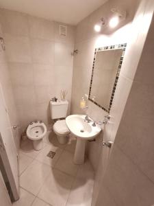 a bathroom with a sink and a toilet and a mirror at Atardeceres in Resistencia