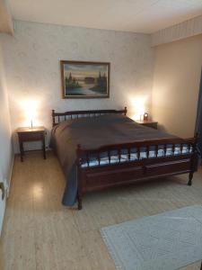1 dormitorio con 1 cama grande y 2 mesitas de noche en Lakeside Villa Lehtiniemi en Pirkkala