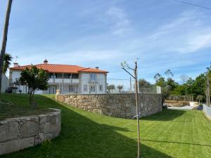 a house with a stone wall and a yard at Casa da Gândara 