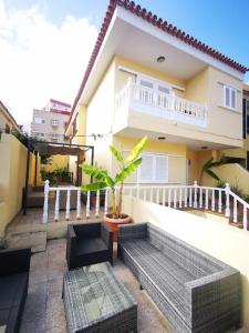 un balcón de una casa con un banco frente a ella en Amplia casa 5 habitaciones en Santa Cruz con zona para trabajar en Santa Cruz de Tenerife
