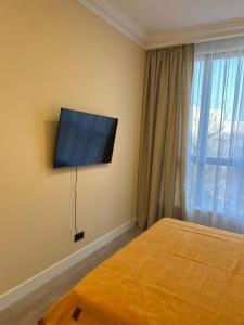 a bedroom with a flat screen tv on the wall at Жк Riverside in Almaty