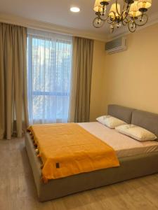 a bedroom with a large bed and a window at Жк Riverside in Almaty