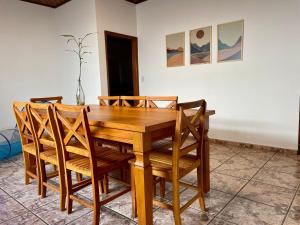 uma mesa de jantar de madeira com cadeiras de madeira em Casa Jabuticaba a 5 min dos Thermas e Hot Beach em Olímpia