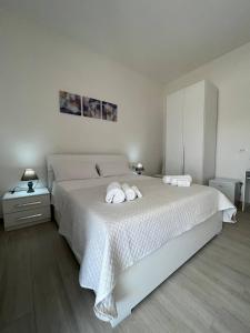1 dormitorio con 1 cama blanca grande y 2 toallas en Central Rooms Posada, en Posada