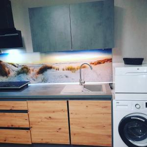 a kitchen with a sink and a washing machine at Apartment am Waldrand 1 Person Nichtraucher mit Einkaufsservice in Itzehoe