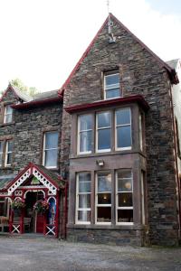 una casa in pietra con una grande finestra e una porta rossa di YHA Buttermere a Buttermere