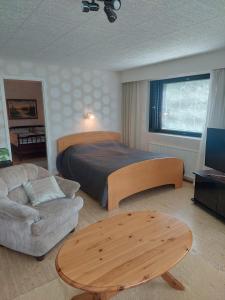 a bedroom with a bed and a couch and a table at Lakeside Villa Lehtiniemi in Pirkkala