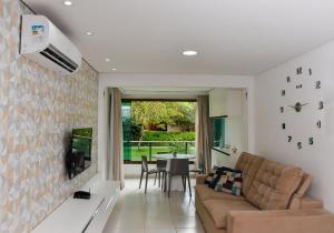 uma sala de estar com um sofá e uma mesa em Carneiros Beach Resort Flat Térreo 2 quartos em Praia dos Carneiros