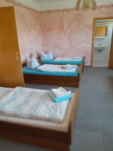 ein Zimmer mit 3 Betten und Handtüchern darauf in der Unterkunft Sport & Freizeit Zentrum Pension in Heudeber