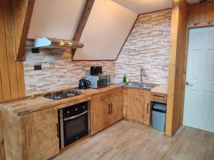 a kitchen with wooden cabinets and a stove top oven at Cabañas Nevados Del Valle in Malalcahuello