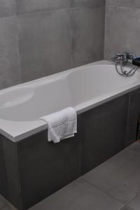 a bathroom with a bath tub with a towel on it at Square Connexions Guest House in Gaborone