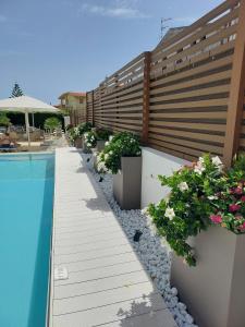 a swimming pool with potted plants next to a building at Hotel Nettuno in Cala Gonone