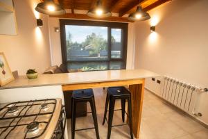een keuken met een aanrecht met krukken en een fornuis bij Studio Los Manzanos in Bariloche