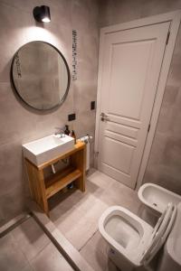 a bathroom with a toilet and a sink and a mirror at Studio Los Manzanos in San Carlos de Bariloche