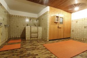 un ampio bagno con doccia e porta in legno di Hotel Tannenboden - Steinbock a Flumserberg