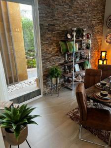 a living room with a table and a brick wall at Luxury villa in seachell sahel el alamein in Sīdī ‘Abd ar Raḩmān