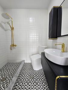 a white bathroom with a sink and a toilet at Boutique Hotel Honey in Kutaisi